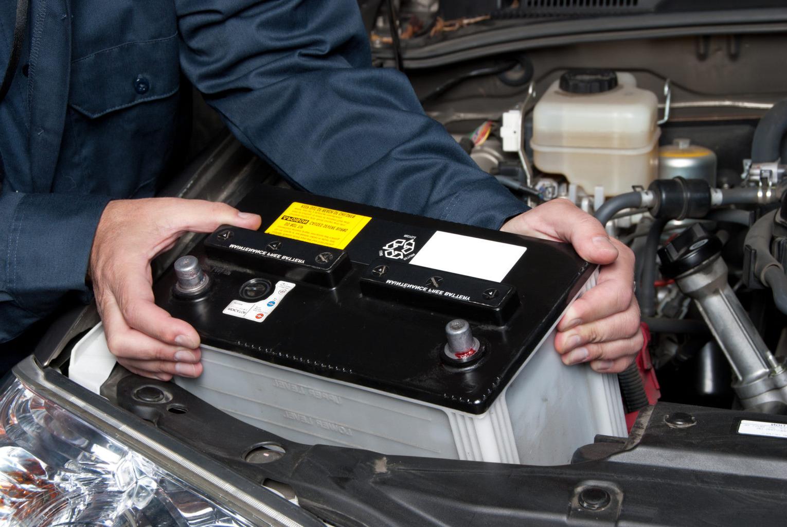 汽车修理工正在安装汽车电池